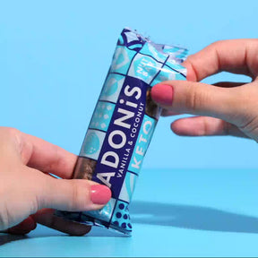 Vanilla & Coconut keto nut bar being broken apart and eaten